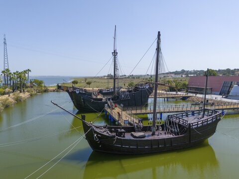 Resting harbour with historical replicas of sailing ships in the water under a clear sky, aerial view, Muelle de las Carabelas, reproductions of La Ni&ntilde;a, La Pinta and La Santa Mar&iacute;a, Museum, Palos de la Frontera, Province of Huelva, Andalusia, Spain