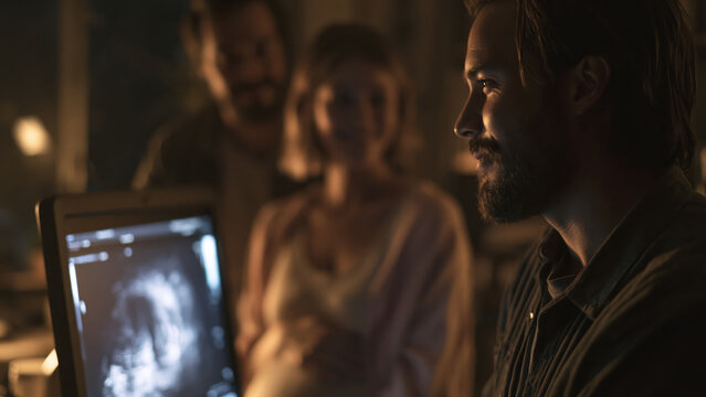 Close-up view of ultrasound monitor showing clear image with observers in background during examination at evening light