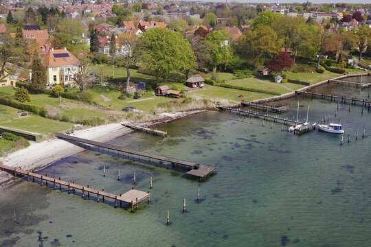 Shot of a coastal town with houses, forest, boats and piers on the water, Svendborg, Danish South Sea, Denmark