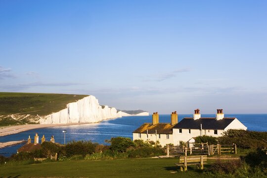 Houses in front of the Seven Sisters chalk cliffs, Seaford, Sussex, England, United Kingdom