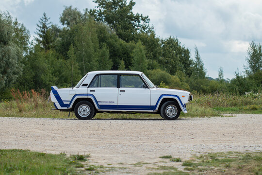 L&auml;&auml;ne County, Estonia - August 9th 2024: Side view of 1980s retro Lada VFTS rally car with white and blue design and Brundza Tuning stickers, parked on a gravel road curve