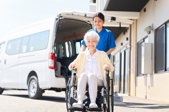 車椅子に座るシニアを迎える外国人介護士