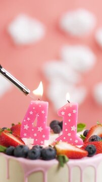 Birthday cake candle number 41. Vertical video of candle and cake on pink background and fire by lighter. Close-up and slow motion