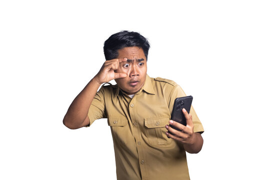 Indonesian civil servant widening eye with fingers in shock while looking at smartphone screen. white background
