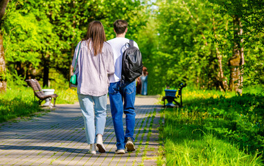 Obraz premium A guy and a girl walk along the path in the city Park 