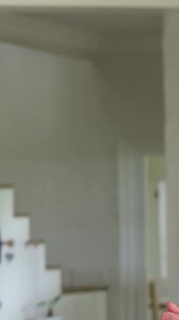 Vertical video: Panning camera left, man in denim wearing VR headset moving to hallway, copy space