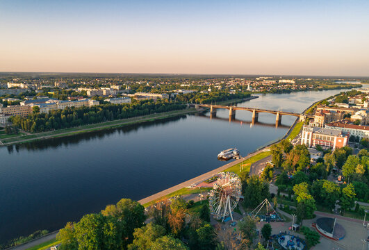 Aerial city view with river, bridge, and amusement park during sunset in a European town