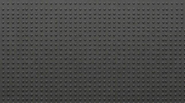 Industrial black rubber texture with raised circular studs, non-slip dark gray floor mat surface, textured synthetic material for grip