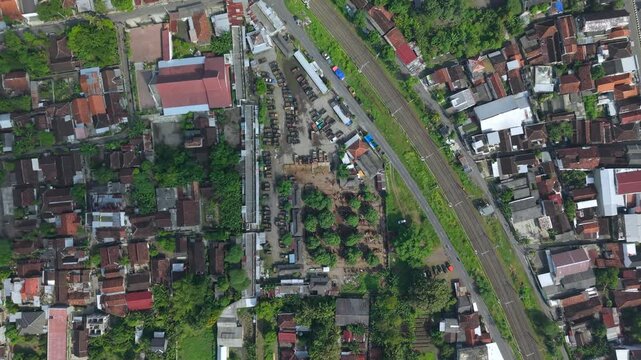Aerial view of Animal Market Prambanan with railway tracks and residential rooftops in Kecamatan Prambanan, Jawa Tengah, Indonesia.
