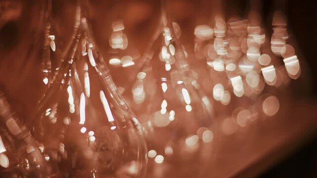 Abstract dynamic motion of upside down wine glasses creating beautiful bokeh and light reflections in a warm reddish brown setting.