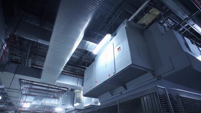 Industrial air handling units and extensive ductwork forming a robust cooling system within a modern facility, optimizing climate control and ensuring efficient operations for sensitive equipment