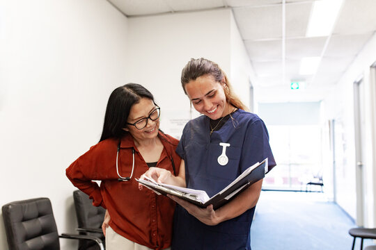 Clinician reviewing binder with colleague in medical facility