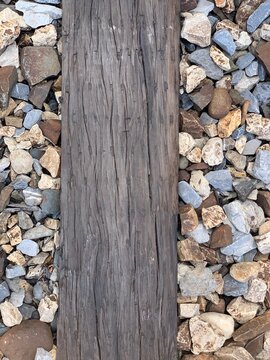 Weathered wooden plank surrounded by various colored pebbles