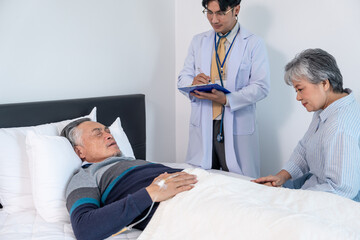 Fototapeta premium scene of asian elderly man patient in bed,on iv drip, got examine from professional doctor and his wife supporting beside