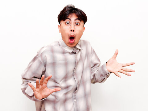 Shocked young Asian man looking at camera with funny open mouth facial expression isolated on white background