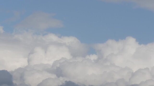 Beautiful White Cumulonimbus Fluffy Clouds Moving on the Sky. Rainy Clouds in a Slideshow on the Sky in a Summer Day.