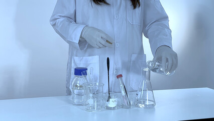 Fototapeta premium Scientist Pouring Liquid into Erlenmeyer Flask for Potassium Carbonate Experiment