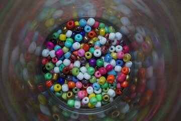 Fototapeta premium A vibrant macro shot of multi-colored plastic craft beads mixed together, creating a bright and colorful pattern.