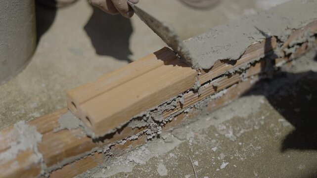 Close Up Of Laying Bricks With Cement Mortar