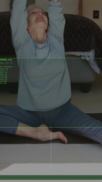 Vertical video: Senior woman using green lines, shifting into straddle and folding right for health