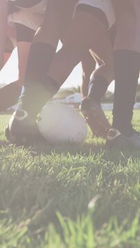 Vertical video: Soccer players jockeying around still ball on grass while glitching, foot rolling