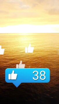 Vertical video: Sunrise sparking blue bubble, thumbs rising, counter climbing for likes over sea