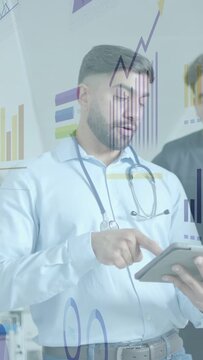 Vertical video: Doctor tapping tablet, explaining medical data to peer while animated charts appear