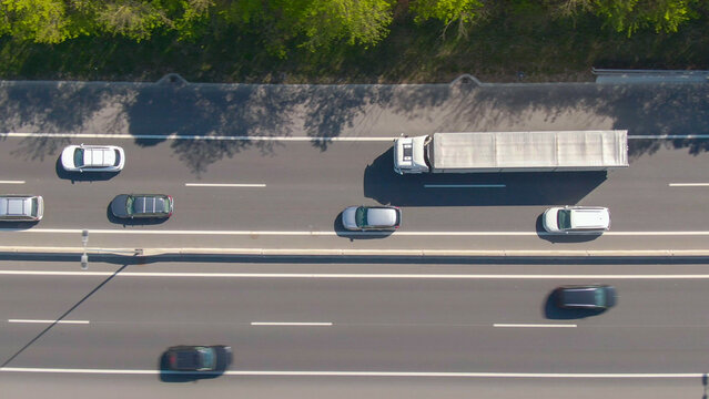 TOP DOWN: Big white truck drives along the freeway during a light traffic jam.