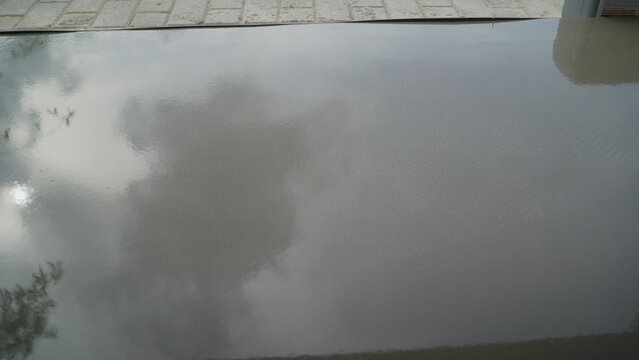 Freshly applied gray epoxy floor coating with sky reflection