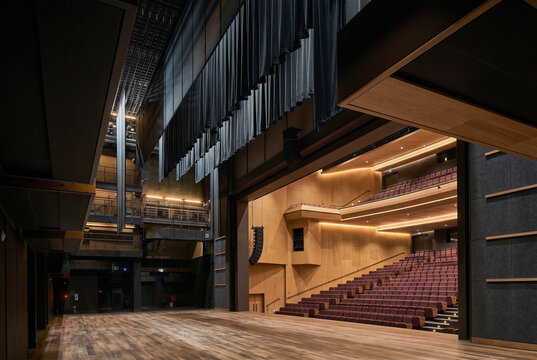 Modern performance hall interior viewed from side stage with tiered seating