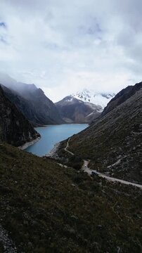 Huaraz, Peru: Forward footage of famous laguna paron in Caraz, Huaraz region, Peru. Surrounded by mountain range and with cloudy dramatic sky, showing cordillera blanca in the background