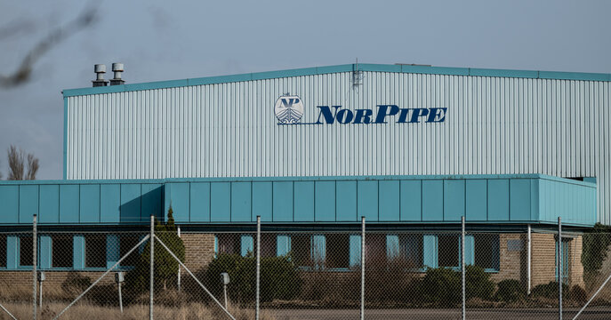 Falkenberg, Sweden - March 28 2026: Industrial warehouse building with NorPipe signage behind fenced perimeter.