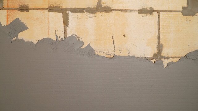 Wet plaster application on aerated concrete block wall. Construction background with copy space