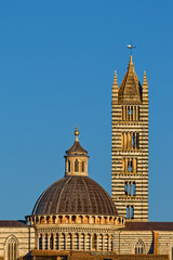 Fototapeta premium Siena Cathedral Duomo and campanile, at sunset, a masterpiece of Italian Romanesque–Gothic architecture