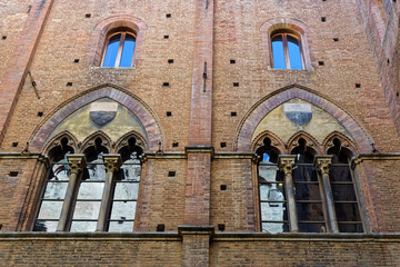 Fototapeta premium Architectural detail of Palazzo Pubblico, historic palace on the Piazza del Campo in Siena. It is one of the principal landmarks of the historic center.