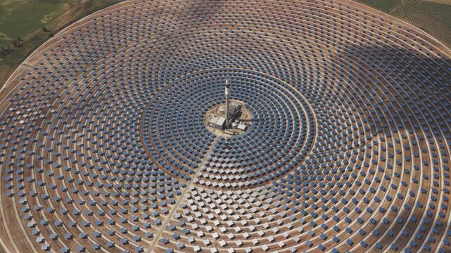 Aerial view of Torresol Energy Gemasolar plant with concentric heliostat mirrors surrounding a central tower in Fuentes de Andalucia, Andalucia, Spain.