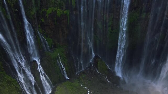 Stunning 4K aerial view of Tumpak Sewu waterfall curtains in East Java, Indonesia.