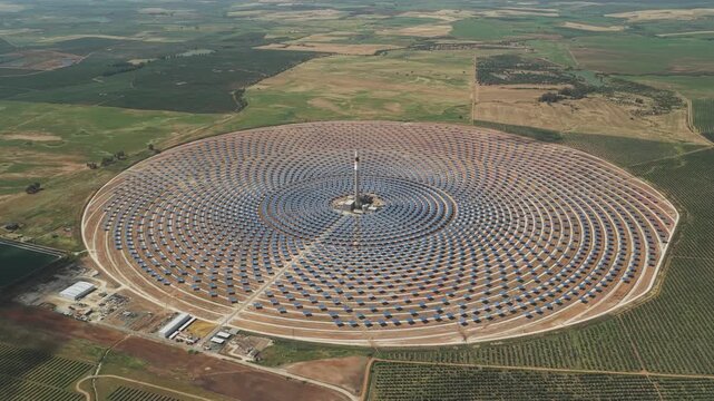 Aerial view of Torresol Energy Gemasolar plant with concentric heliostat mirrors surrounding a central tower in the rural landscape of Fuentes de Andalucia, Andalucia, Spain.