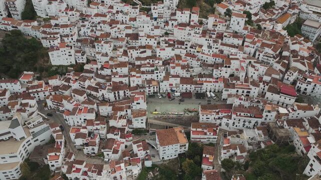 Aerial view of the traditional white houses and terracotta rooftops of the hillside village of Casares, Andalusia, Spain.