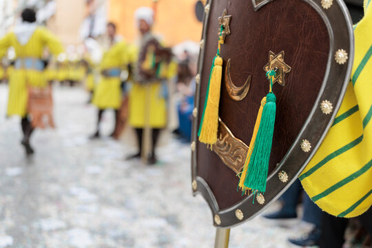 Primer plano de escudo her&aacute;ldico con flecos decorativos en desfile de moros y cristianos