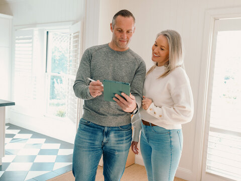 Two adults collaborating with mobile phone at home