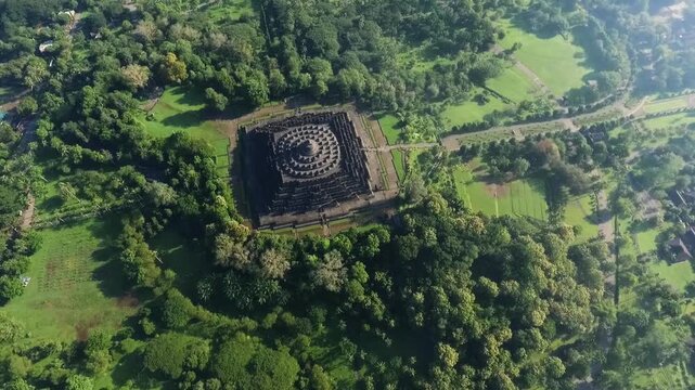 Aerial view of Borobudur Temple a Buddhist temple in Indonesia surrounded by lush green forest.