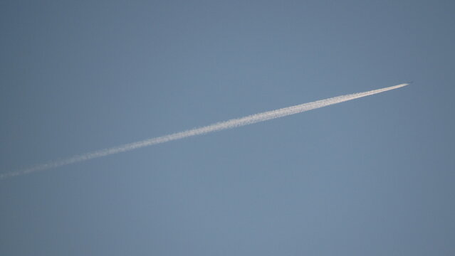 Commercial airplane flying high in a clear blue sky