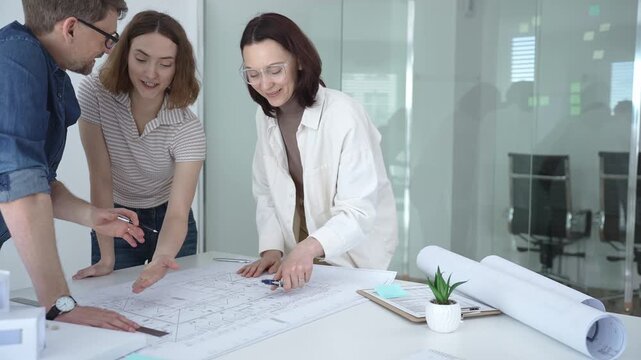 Group of architects discussing building blueprints and a structural model, collaborating on an urban development project in a modern office environment. Architects at work