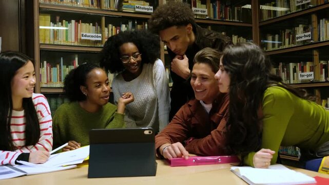 Young multiethnic students collaborating on a project using a digital tablet in a library