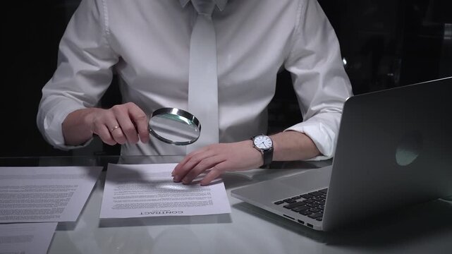 Businessman reviewing document contract terms with magnifying glass, paying attention to important fine print details. Audit and taxes in business