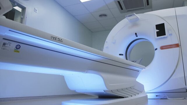 Bright hospital MRI room with patient table and large scanner, showing clean diagnostic equipment for radiology examination and healthcare technology.