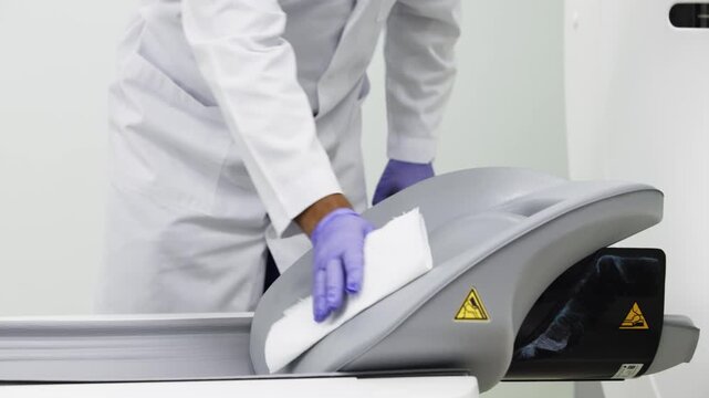 Close-up of doctor operating MRI equipment in a radiology room, preparing advanced diagnostic scan for patient examination and healthcare research.