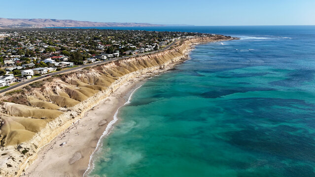 Port Willunga Beach, Adelaide, South Australia &ndash; 4K Aerial Drone view of Australia Beach, Historic Jetty Ruins, Limestone Cliffs, Golden Sand, Clear Blue Ocean Coastline, and Coastal Houses