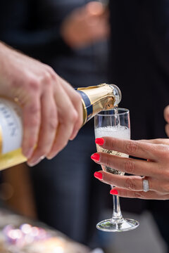 Service de champagne lors d&rsquo;un &eacute;v&eacute;nement festif en ext&eacute;rieur avec invit&eacute;s et ambiance conviviale.